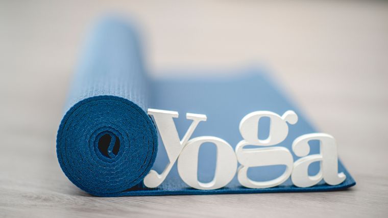 Yoga word on top of a yoga mat